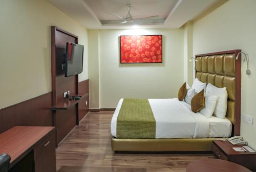 a hotel room with a bed and a flat screen tv at Hotel Cama in Chandīgarh