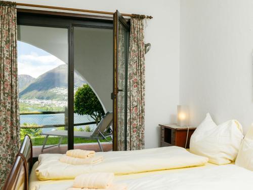 Duas camas num quarto com uma janela grande em Apartment Miralago - Utoring-24 by Interhome em Piazzogna