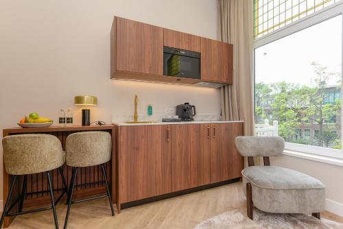 a kitchen with a counter and two bar stools at Novallure Villa Margaretha - Short Stay Apartments in Rijswijk