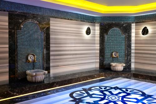 a bathroom with two sinks and two mirrors at Club Big Blue Suit Hotel - All Inclusive Plus in Alanya