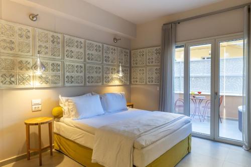 a bedroom with a bed and a balcony with a table at Ionian Plaza Hotel & Spa in Argostoli