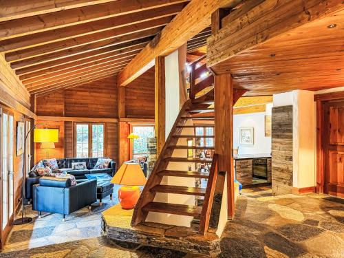 a living room with a wooden staircase in a house at Holiday Home Les Clèves by Interhome in Nendaz