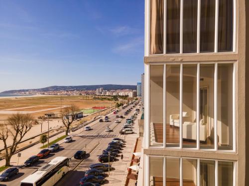 a building with a view of a street with parked cars at Vila Gale Collection Figueira da Foz in Figueira da Foz