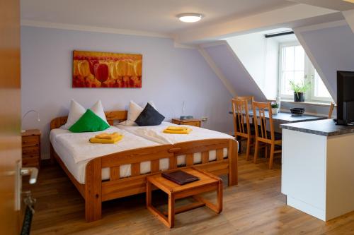ein Schlafzimmer mit einem Bett und einem Tisch sowie eine Küche in der Unterkunft Waldhof-Iphofen in Iphofen