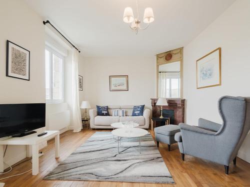 un salon avec un canapé et une télévision dans l'établissement Apartment L'Anse by Interhome, à Dinard