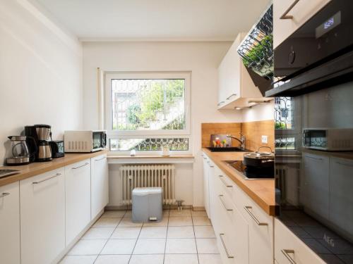 een keuken met witte kasten en een raam bij Apartment Terrassenwohnung am Kurpark by Interhome in Lahnstein