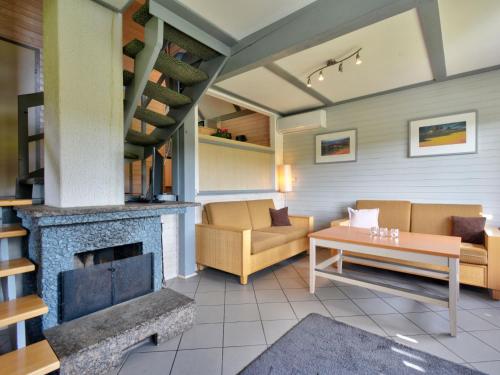 a living room with a couch and a fireplace at Holiday Home Dorf 1-Haus 14 by Interhome in Kirchheim