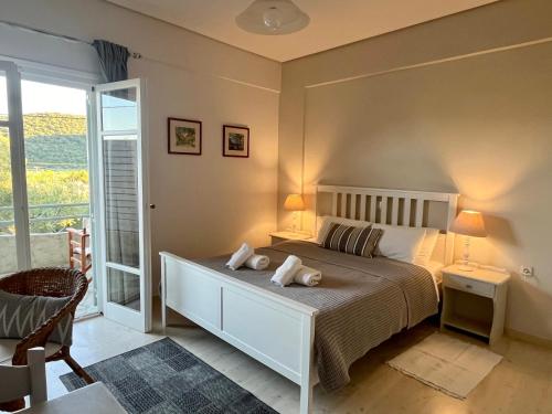 1 Schlafzimmer mit einem weißen Bett und einem Balkon in der Unterkunft Nefeli Studios in Vathy
