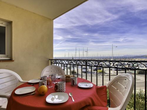 une table avec une nappe rouge et une vue sur un pont dans l'établissement Apartment Les Rivages de Coudoulière-31 by Interhome, à Six-Fours-les-Plages