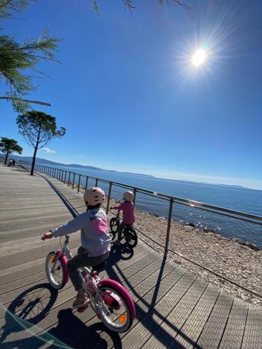伊埃爾的住宿－Haut de villa entre mer et campagne，海滩旁木板路上的2辆儿童自行车