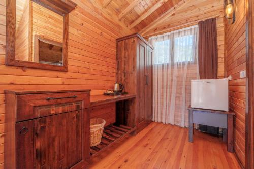 a log cabin with a refrigerator and a desk in it at Sea Valley Lodge in Faralya