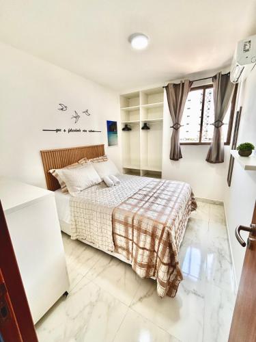 a white bedroom with a bed and a window at Flat Sand Beach-IntermaresPB in Cabedelo