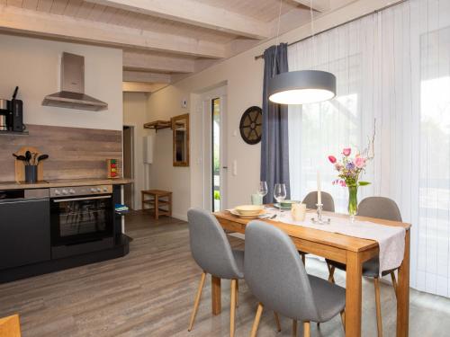 a kitchen and dining room with a wooden table and chairs at Apartment Nachtigall II-2 by Interhome in Osten