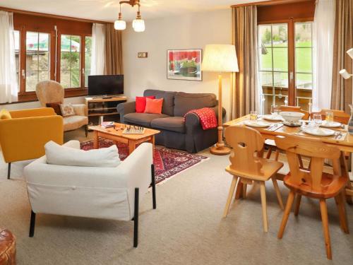 uma sala de estar com um sofá e uma mesa em Apartment Chalet Simmental P-3 by Interhome em Zweisimmen