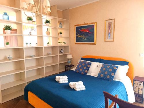 a bedroom with a blue bed and white shelves at Casa Luca in Forza dʼAgro