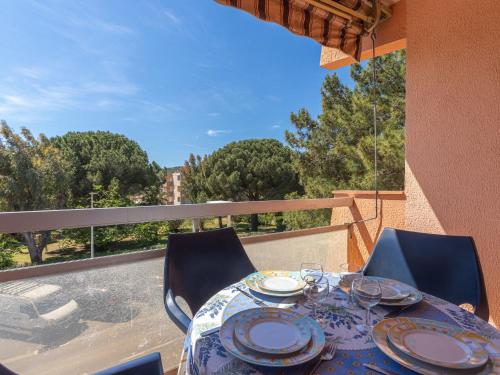 une table et des chaises sur un balcon avec vue dans l'établissement Apartment L'Amirauté by Interhome, à Bormes-les-Mimosas