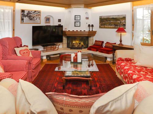 een woonkamer met rode en witte banken en een open haard bij Apartment Marie-Soleil by Interhome in Gstaad