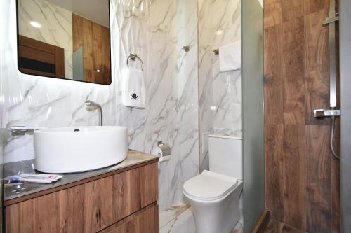 La salle de bains est pourvue d'un lavabo blanc et de toilettes. dans l'établissement The marble ink space 10, à Erevan
