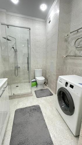 une machine à laver dans une salle de bain avec toilettes dans l'établissement # 51 Светлая квартира в ЖК Лагуна, à Atyraū