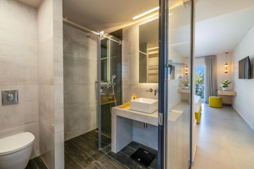 a bathroom with a sink and a shower and a toilet at Ionian Plaza Hotel & Spa in Argostoli