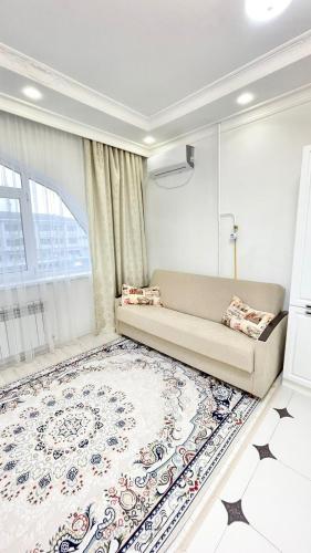 - un salon avec un canapé et un grand tapis dans l'établissement # 51 Светлая квартира в ЖК Лагуна, à Atyraū