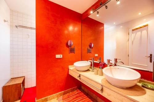 un bagno con due lavandini e una parete rossa di Casa Marino a Sant Francesc Xavier