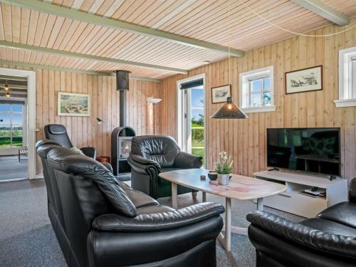 ein Wohnzimmer mit Ledermöbeln und einem TV in der Unterkunft Holiday Home Nanja - 759m from the sea in NW Jutland by Interhome in Løkken