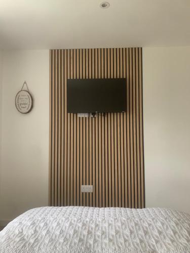 Saint Columb MinorにあるWrens Nestのベッドルーム1室(ベッド1台、壁掛けテレビ付)