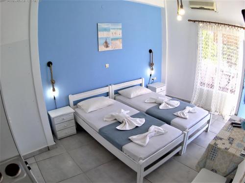 twee bedden in een blauwe kamer met handdoeken erop bij Apanemia 2 in Kinion