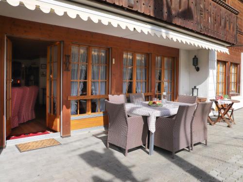 un patio avec une table et des chaises et un bâtiment dans l'établissement Apartment Marie-Soleil Sud by Interhome, à Gstaad