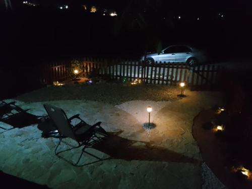 two chairs and a candle in a courtyard at night at La casetta sotto l'albero LA CAROVANA GITANA in Vasto