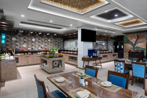 a dining room with a table and a kitchen at Vivanta Jamshedpur, Golmuri in Jamshedpur