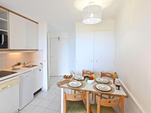 une cuisine avec une table et des chaises dans une pièce dans l'établissement Studio Le Village - C2 105 by Interhome, à Agay