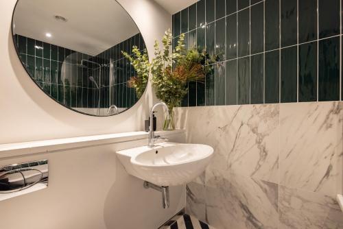 bagno con lavandino e specchio di Modern, Luxury 2-Bed Home with Private Balcony a Londra