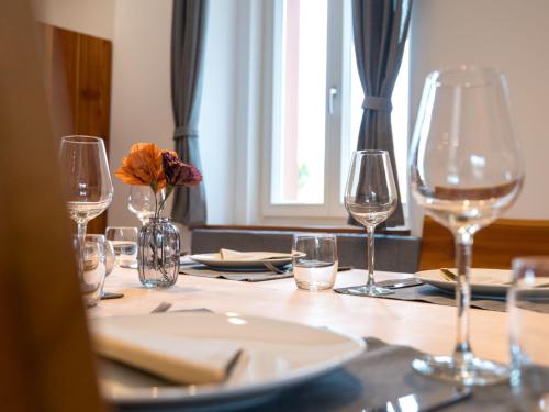 a table with wine glasses and a plate on it at Apartment Altes Zollhaus-1 by Interhome in Fischbach bei Dahn