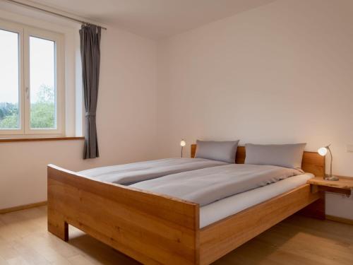 a bedroom with a wooden bed with a window at Apartment Altes Zollhaus-1 by Interhome in Fischbach bei Dahn