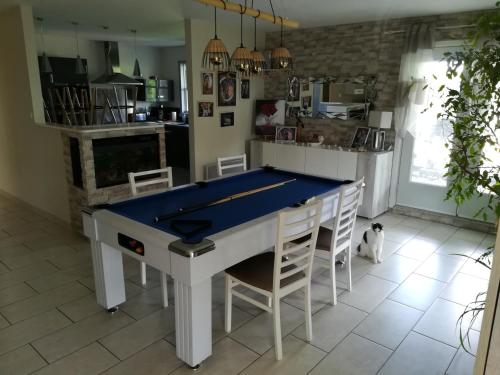 - une cuisine avec une table de ping-pong et des chaises dans l'établissement Notre nid d'amour - jacuzzi, piscine, billard, bar extérieur, terrain de boules, à Saint-Sernin-du-Bois