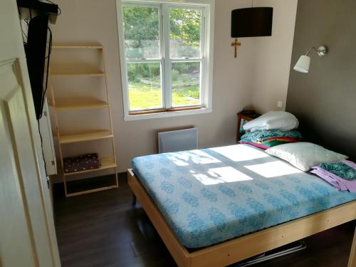 een kleine slaapkamer met een bed en een raam bij Notre nid d'amour in Saint-Sernin-du-Bois