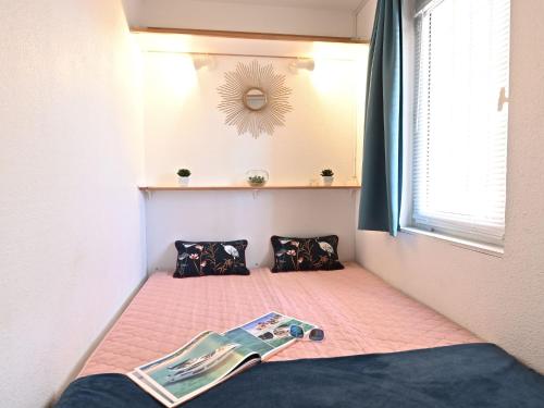 - une chambre avec un lit et un magazine dans l'établissement Studio Le Belvédère - R8 240 by Interhome, à Agay