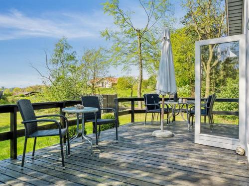 a deck with chairs and a table and an umbrella at Holiday Home Anne - 150m from the sea in SE Jutland by Interhome in Børkop