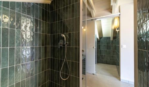 a bathroom with a shower with green tiled walls at Ionian Plaza Hotel & Spa in Argostoli