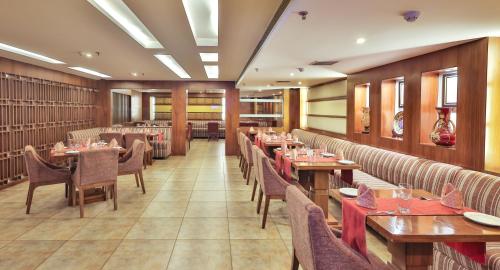 a dining room with wooden tables and chairs at Hotel Cama in Chandīgarh