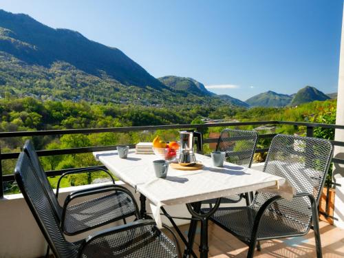 a table and chairs on a balcony with a view at Apartment Villaggio Sureggio - App- C1 by Interhome in Lugaggia