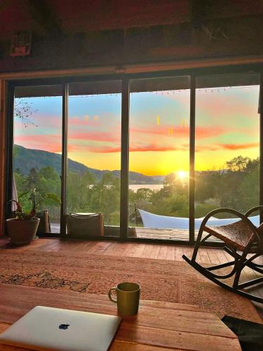 a laptop sitting on a table in front of a window at SHIZENTOYA Privete cottage for nature experience LakeView! in Lake Toya