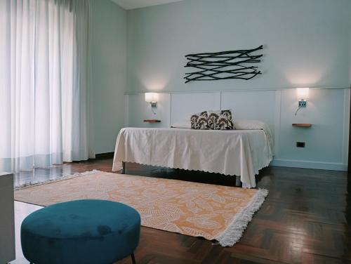 een slaapkamer met een bed en een blauwe poef bij Le Terrazze di Mineo in Cinisi