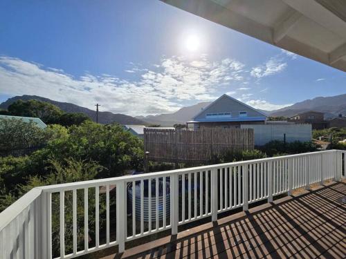 a balcony with a white fence and a view of the ocean at Fijnbos in Pringle Bay