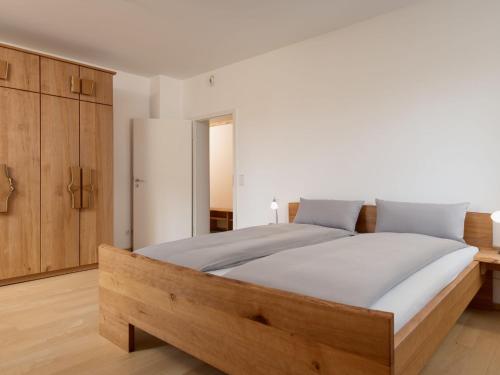 a bedroom with a large bed and wooden cabinets at Apartment Altes Zollhaus-2 by Interhome in Fischbach bei Dahn