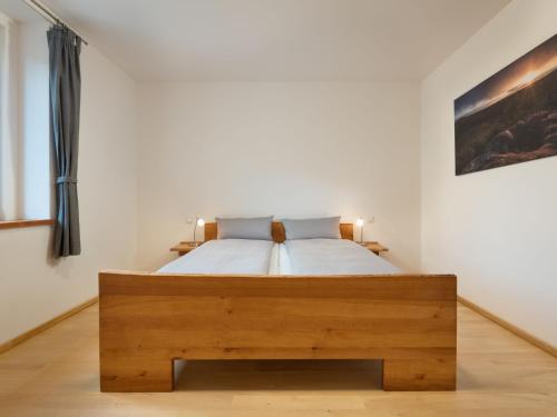 a bedroom with a bed with a wooden frame at Apartment Altes Zollhaus-2 by Interhome in Fischbach bei Dahn
