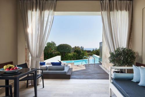 a living room with a couch and a table at Aquagrand Artistic Luxury Beach Resort - Adults Only in Líndos