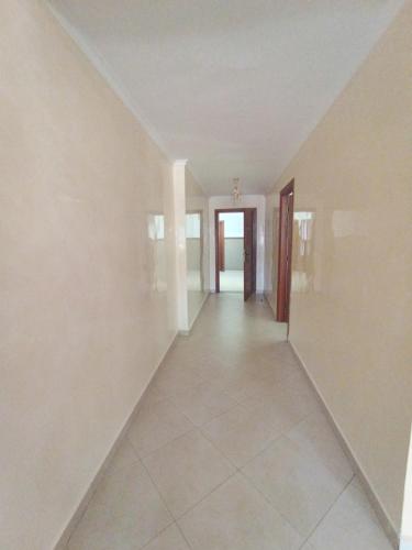an empty hallway with a hallway leading to a door at المضيق 